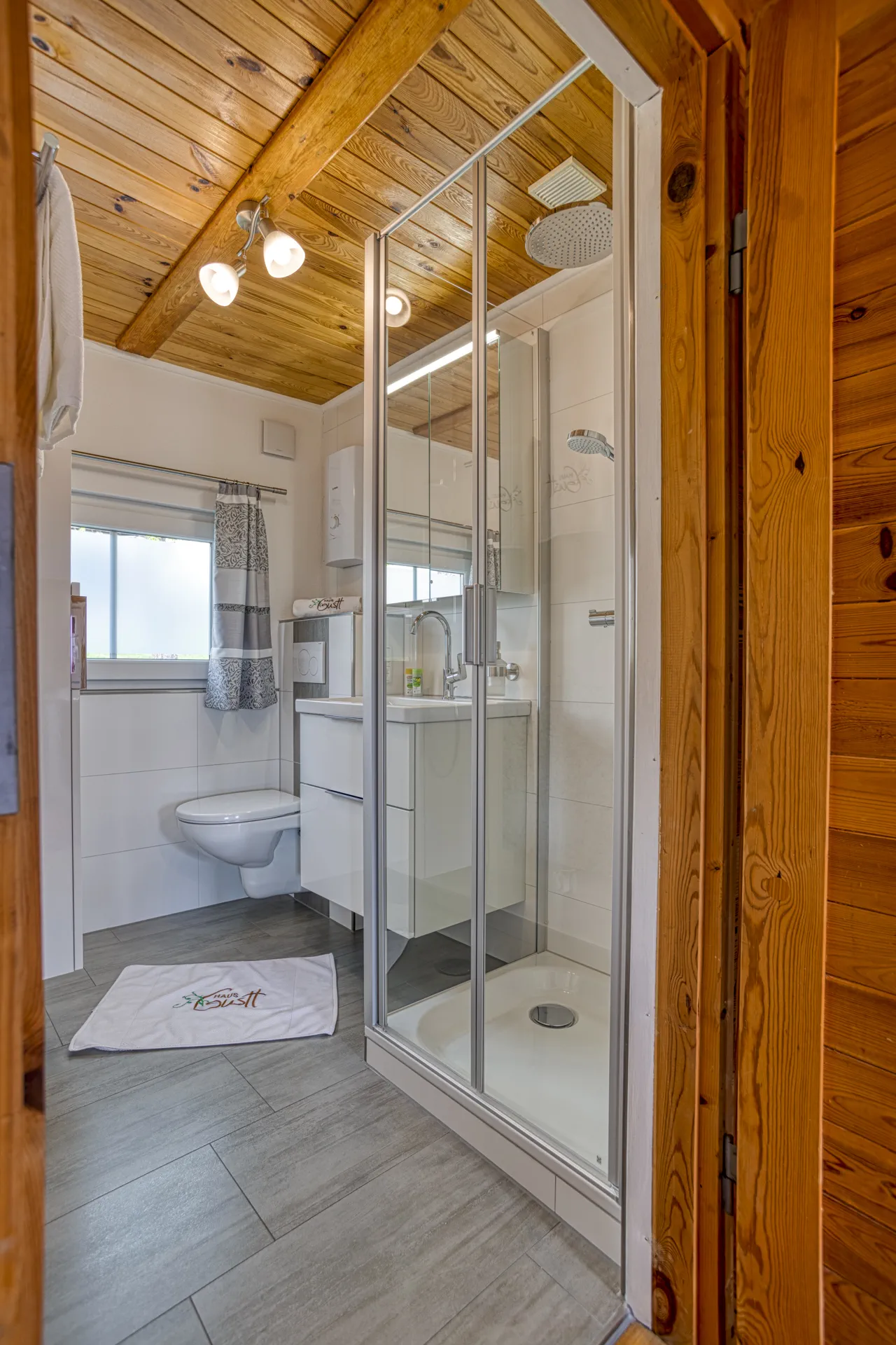 Modernes Badezimmer mit Dusche, WC und hellen Fliesen