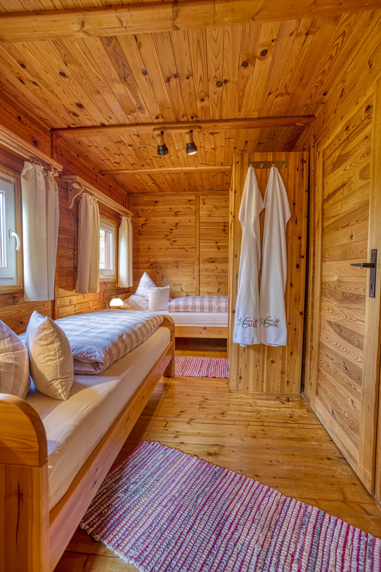 Zweites Schlafzimmer mit Einzelbetten und Holzdecke im Ferienhaus Gustl